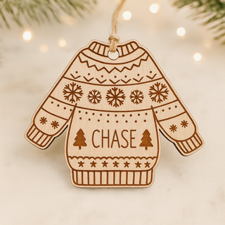 Wooden ornament shaped like a sweater with 'CHASE' text, snowflakes, and trees on a light background.