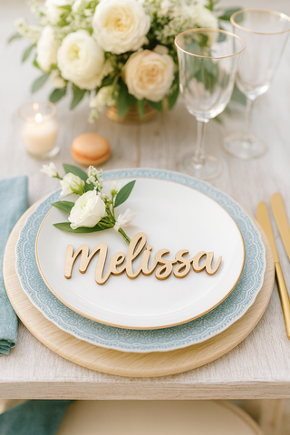 Table setting with 'Melissa' nameplate, floral arrangement, and glasses on a light background